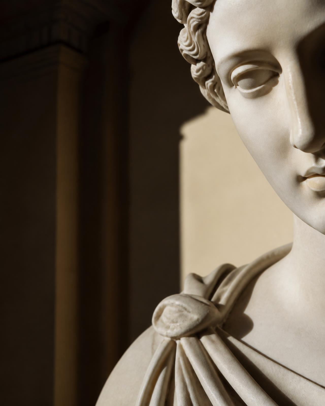 Detalhe em mármore de uma escultura greco-romana sob luz lateral